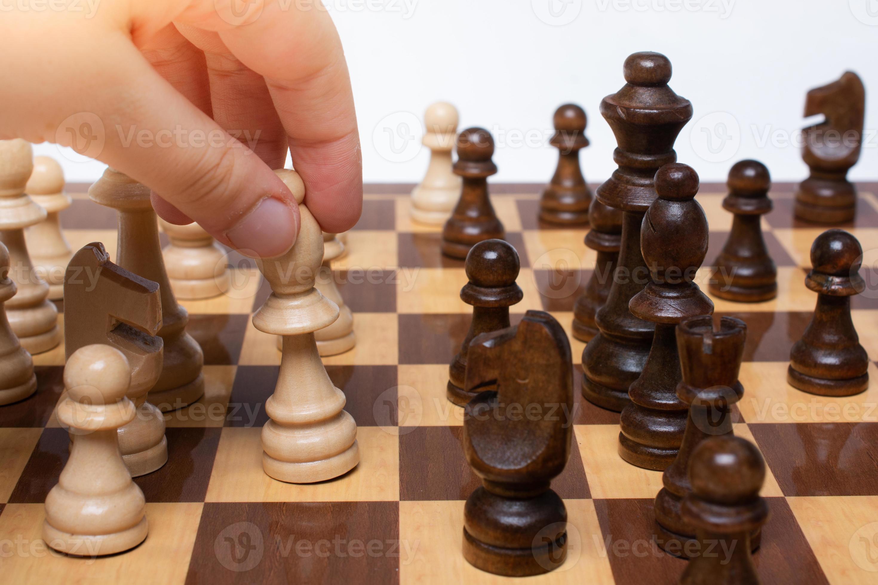mão fazendo um movimento com peças de xadrez de madeira no xadrez